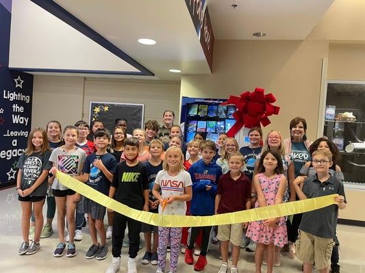 students exctied about ribbon cutting ceremony for book vending machine